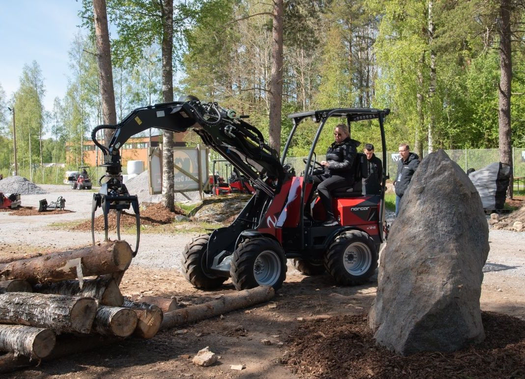 Minilaster med gripeklo løfter trestamme