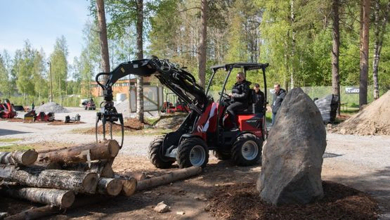 Minilaster med gripeklo løfter trestamme